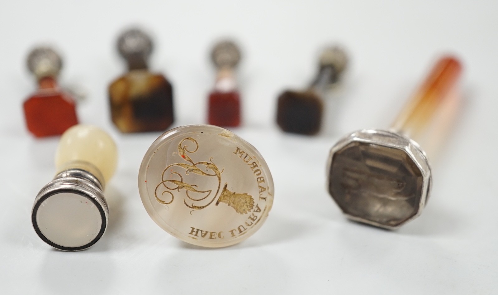 Five assorted 19th century white metal mounted agate seals, largest 61mm, a similar white metal and mother of pearl mounted seal and a white chalcedony seal with monogrammed matrix.